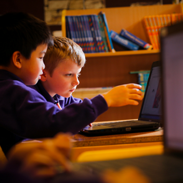 two boys looking at computer screen