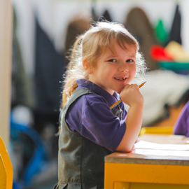 primary school aged girl smiling at desk