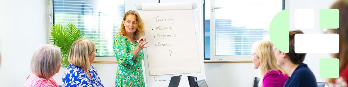 Training session with learners around the table and trainer with flip board taking the session