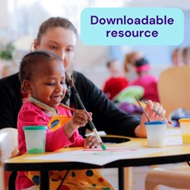 A smiling child painting with a brush, guided by an adult female teacher in a colourful classroom. Text overlay says Downloadable resource. 