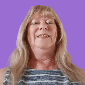 Smiling woman with long, blonde hair against a purple background, wearing a blue and white striped top. 