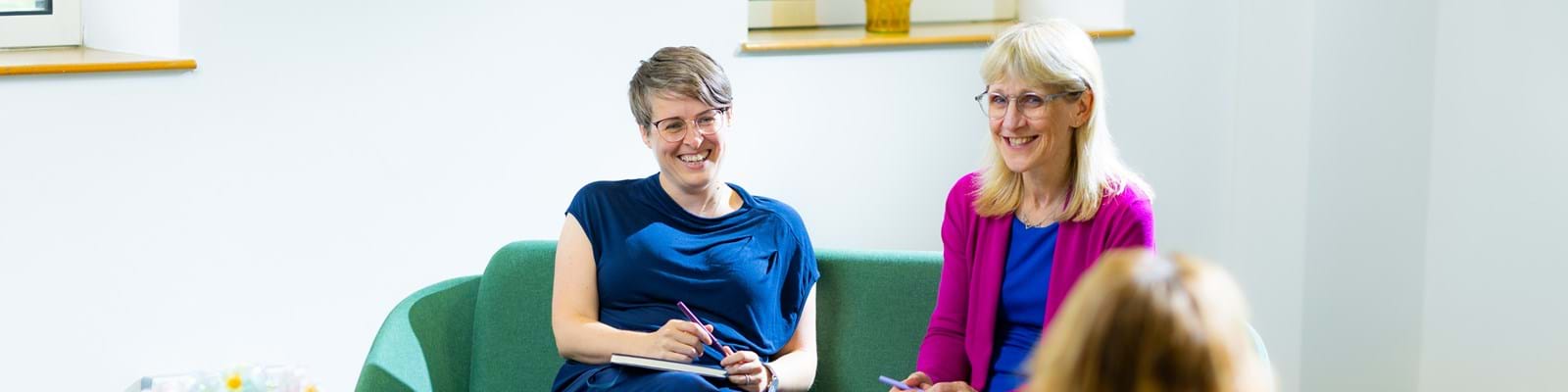 Two women smiling in a professional setting.