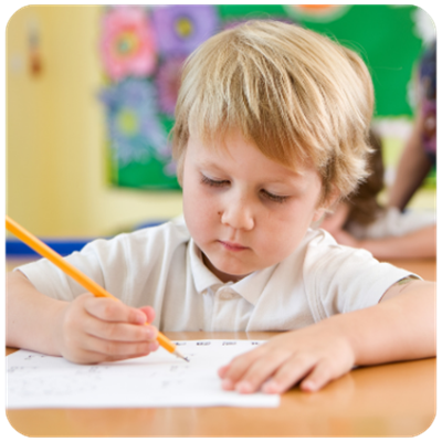 Child sitting at a desk writing with a pencil