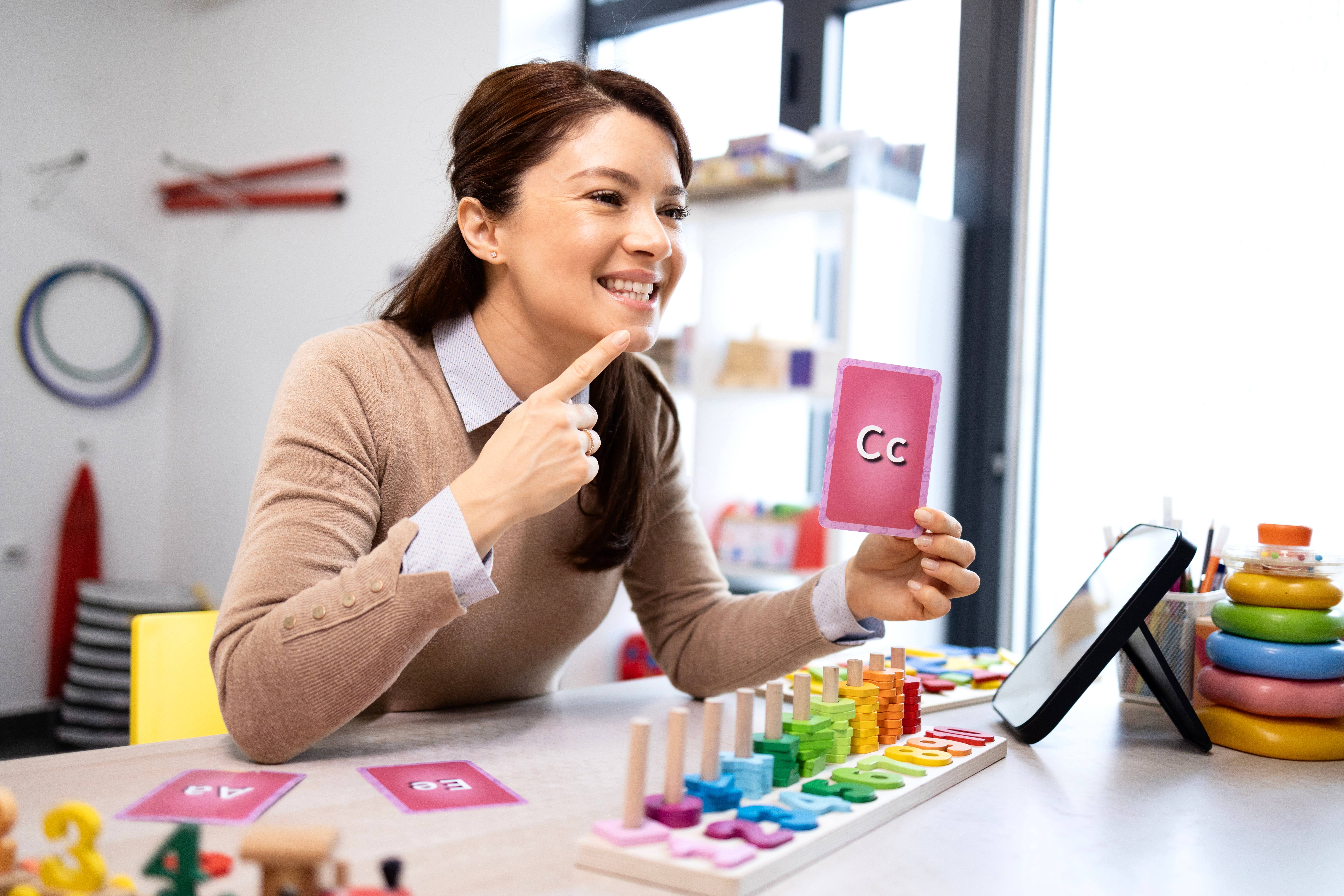 ALT - Teacher pointing at mouth and sounding the letter c