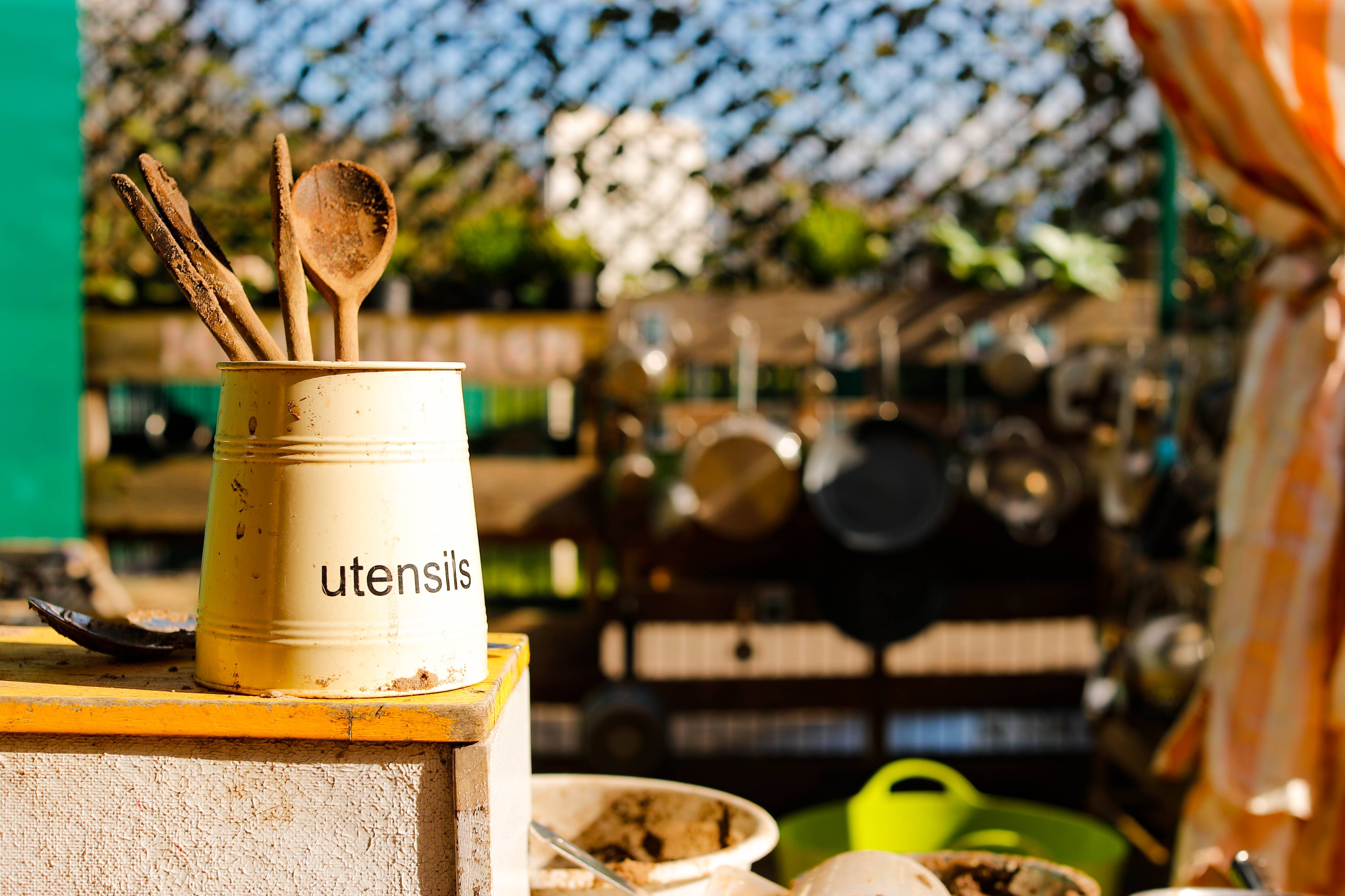 ALT - Outside kitchen with utensils in a pot and hanging saucepans